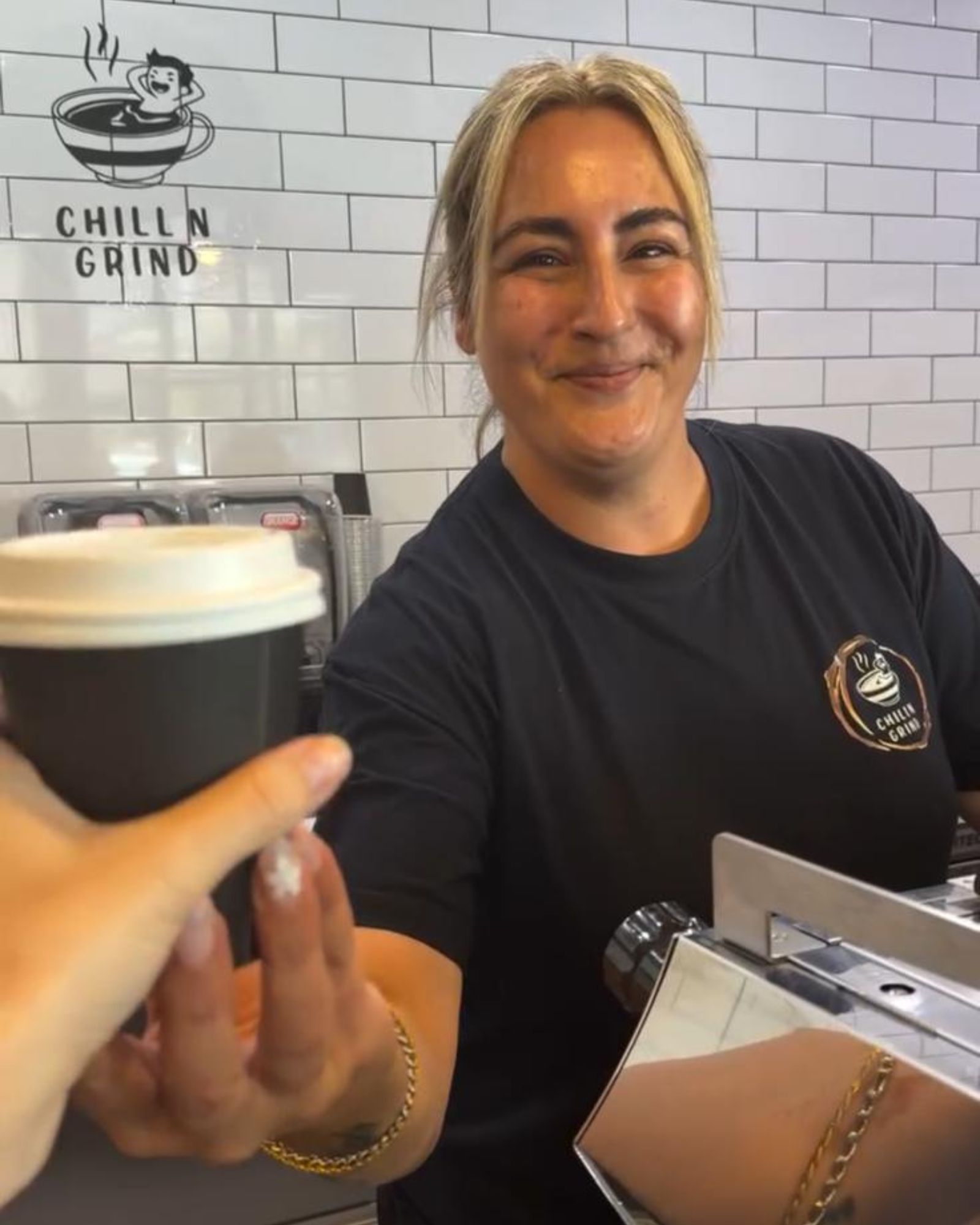 Coffee being handed to a customer at Chill N Grind