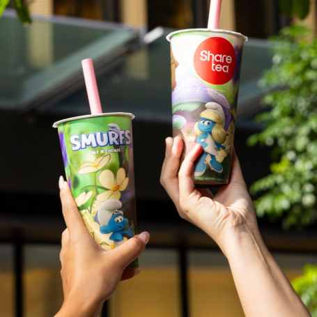2 hands hold up a Sharetea x Smurfs drink.