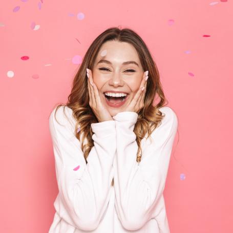 Surprised woman with confetti falling around her